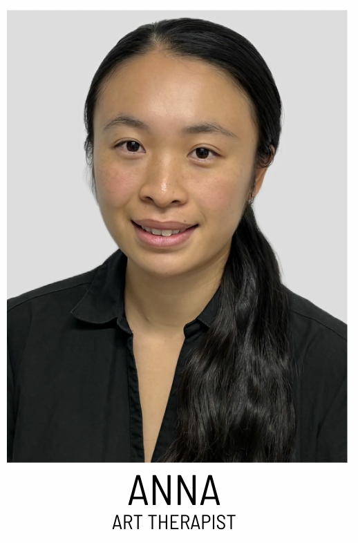 Portrait of Anna, an art therapist, smiling in a black blouse for a staff headshot